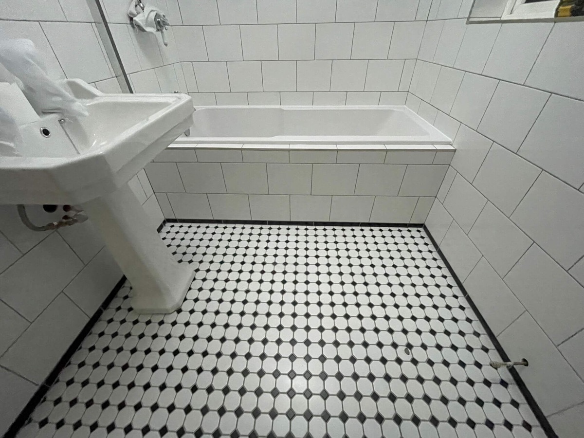 Small black and white mosaic tiling with Victorian bathroom suite